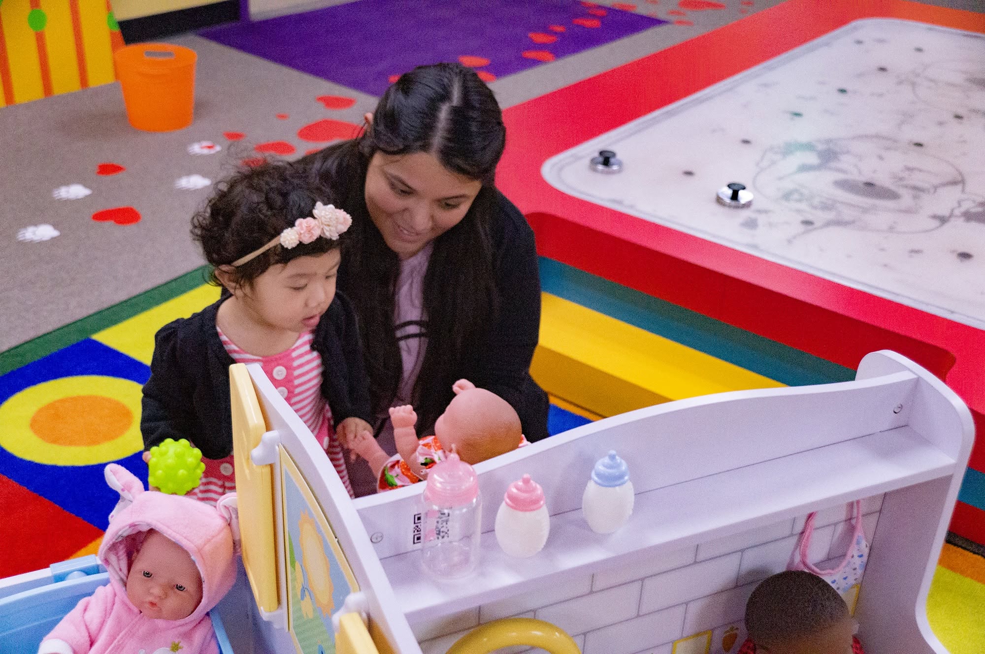 Mom and Kid playing together at the baby station